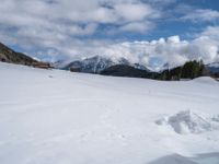 there is snow piled up on the ground and mountains in the distance of the scene