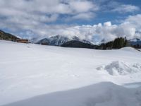 there is snow piled up on the ground and mountains in the distance of the scene