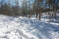 the trail is snow covered in footprints in the forest or mountain top sloped area