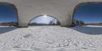 a man with skis is coming through a snow - covered tunnel under a blue sky