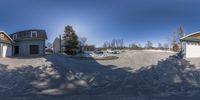 some snow houses and cars and trees and sky in a 360 view view mirror camera