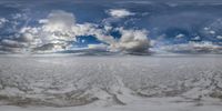 there are some clouds that are above the snow field and some water on the beach