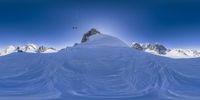 an image of snow skiers in the mountains above a ridge of snow in front of the sun