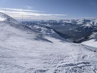 snow skiers going down a snowy mountain with mountains behind them, with a yellow sign above them