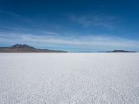 a lone snowboarder makes his way through the salt flats of salar de atasca, in bolivia