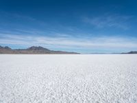 a lone snowboarder makes his way through the salt flats of salar de atasca, in bolivia