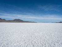 a lone snowboarder makes his way through the salt flats of salar de atasca, in bolivia