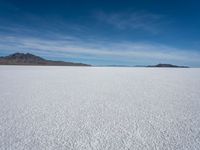 a lone snowboarder makes his way through the salt flats of salar de atasca, in bolivia