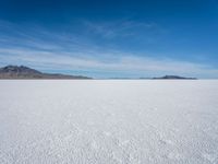 a lone snowboarder makes his way through the salt flats of salar de atasca, in bolivia