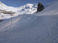 people on snowboards going down a snowy hill next to the ski resort at the base of a mountain