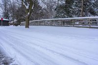 a person snowboarding down the road near a small wooden bridge and some trees on the side of the street