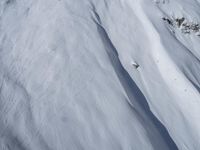 a skier is coming down a steep mountain slope in snows on the other side