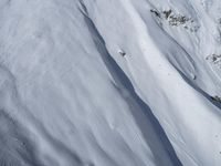 a skier is coming down a steep mountain slope in snows on the other side