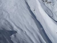 a skier is coming down a steep mountain slope in snows on the other side