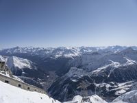 someone standing atop a snowy mountain slope with skis on their feet and in the air