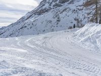 there is snow everywhere that has been cleared off the road with ski equipment on it