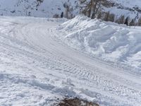 there is snow everywhere that has been cleared off the road with ski equipment on it