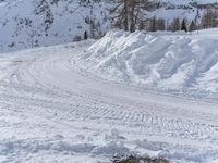 there is snow everywhere that has been cleared off the road with ski equipment on it