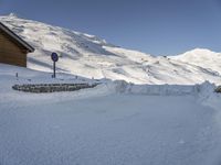 a snow covered hill with a small building and a sign indicating to let people know where it belongs