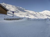 a snow covered hill with a small building and a sign indicating to let people know where it belongs