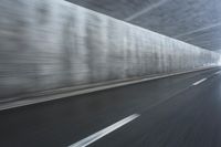 a blurry image of a road in an tunnel with rain, as viewed from the front seat of a car