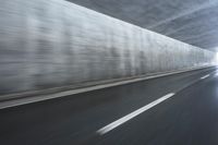 a blurry image of a road in an tunnel with rain, as viewed from the front seat of a car