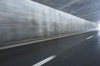 a blurry image of a road in an tunnel with rain, as viewed from the front seat of a car