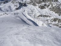 a man riding skis down the side of a snow covered mountain slope top in winter