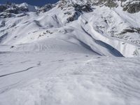 a man riding skis down the side of a snow covered mountain slope top in winter