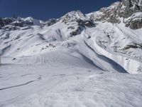 a man riding skis down the side of a snow covered mountain slope top in winter