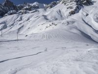 a man riding skis down the side of a snow covered mountain slope top in winter