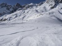 a man riding skis down the side of a snow covered mountain slope top in winter