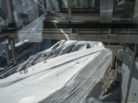 the view from a cable car of a snow covered slope and tracks in the snow