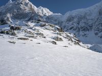 a man on skis stands on the snowy slope at the foot of the mountain