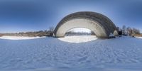 a bridge that is standing in the snow by itself of a snowbank and trees