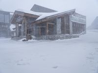 the big cabin is sitting in front of a big building of snow and snow flakes