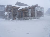 the big cabin is sitting in front of a big building of snow and snow flakes