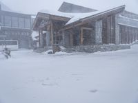 the big cabin is sitting in front of a big building of snow and snow flakes