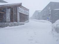 the big cabin is sitting in front of a big building of snow and snow flakes