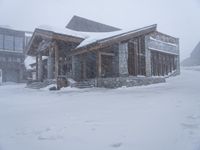 the big cabin is sitting in front of a big building of snow and snow flakes