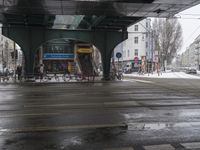 a snowy city street has buildings in the back ground with some bikes on them outside and on top