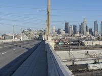 power lines above a cityscape with a railway bridge in the background on a clear, autumn day