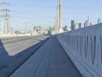 power lines above a cityscape with a railway bridge in the background on a clear, autumn day