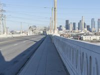 power lines above a cityscape with a railway bridge in the background on a clear, autumn day