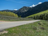 the road is paved with yellow markings and has a snowy mountain range in the background