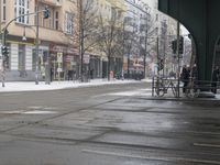 a man is riding on his bike and walking in the street as snow melts the ground