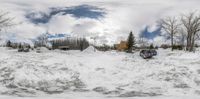 cars parked in a lot behind some snow in the snow in front of a house