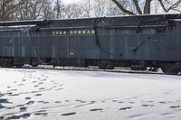 tracks and footprints in snow leading to a dark blue traincarck with the word york durham written on it