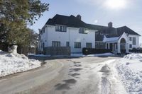 a long driveway is lined with snow leading to the main house of the estater