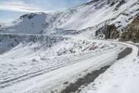 a car is driving down a winding snowy road as the rest goes in order to reach the top